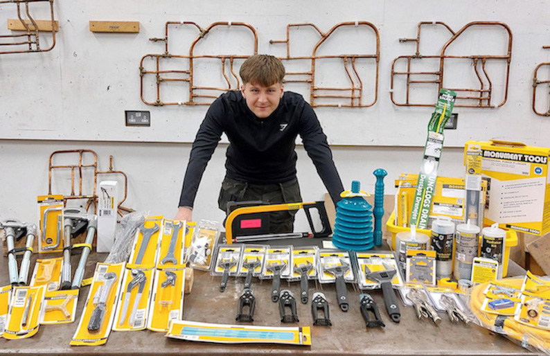 student standing at a workbench with tools