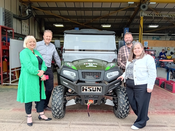 Group of people standing next to a UTV