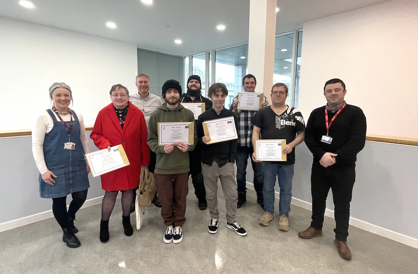 Group of people standing with certificates