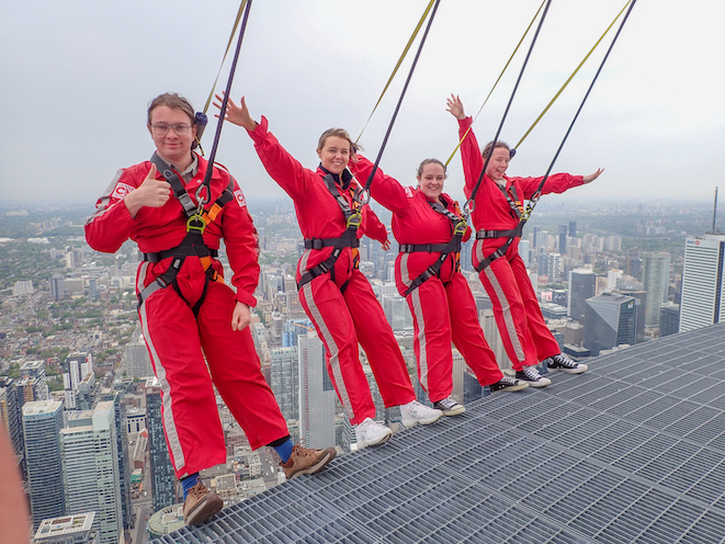 Group of people hanging off the edge of a tall building