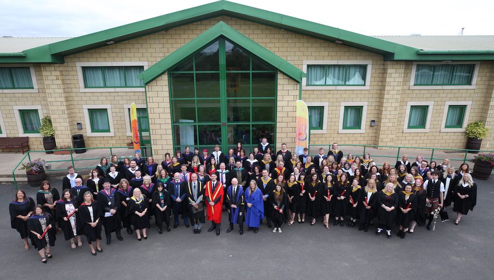 Group of graduates and staff outside a building