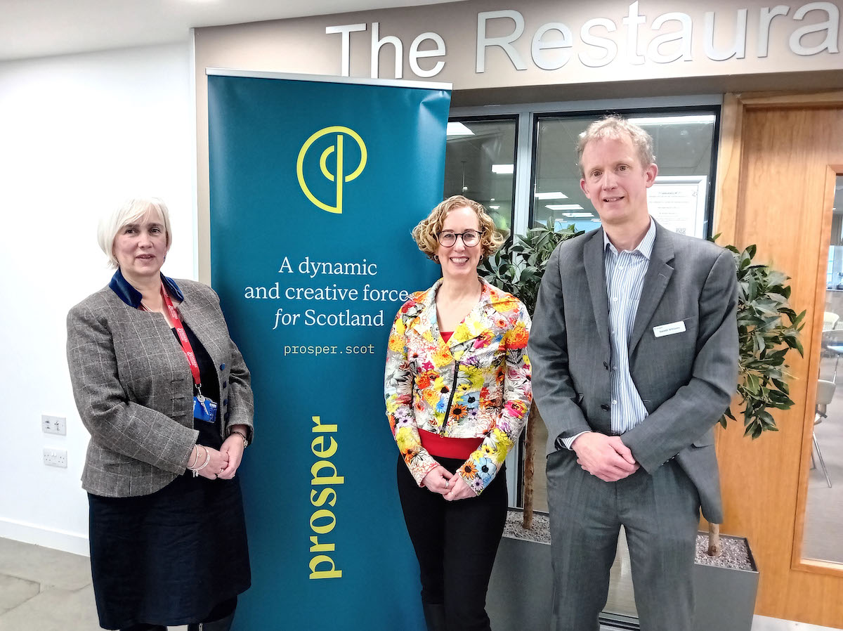 A group photograph of three people standing outside Borders College Restaurant