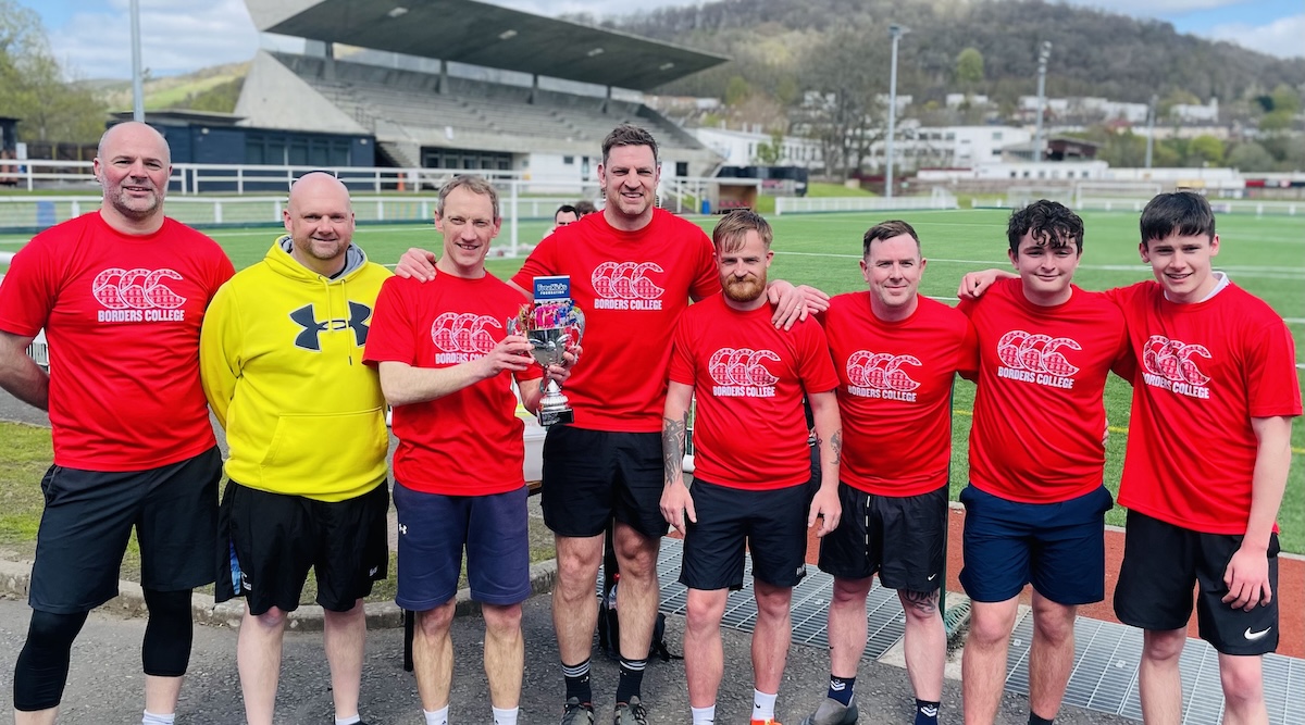 Group of football players sporting the winners trophy