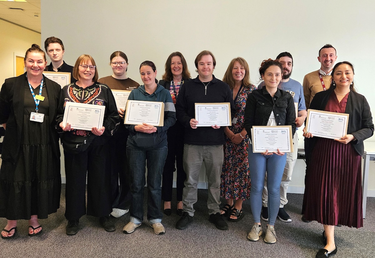 Group of people standing with certificates in hand