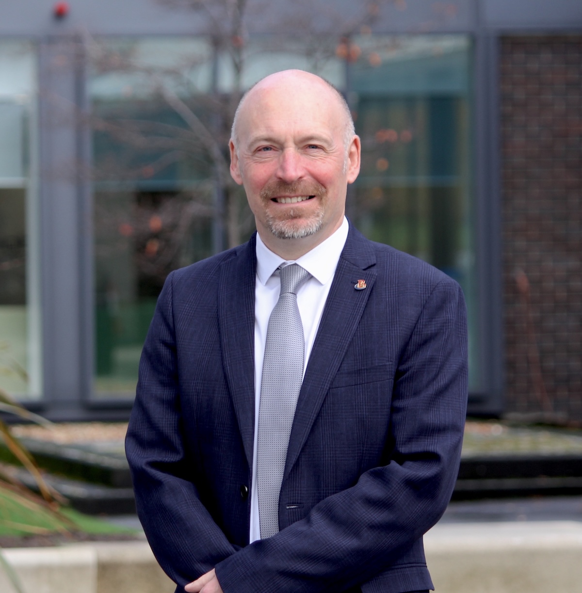 Photograph of Borders College Principal Pete Smith standing outside a college campus