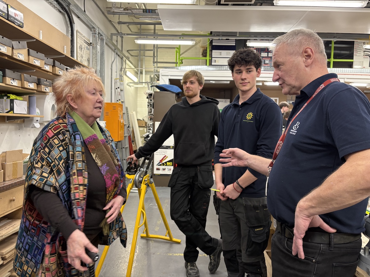 MSP Christine Grahame standing speaking with borders college staff and students in an electrical workshop