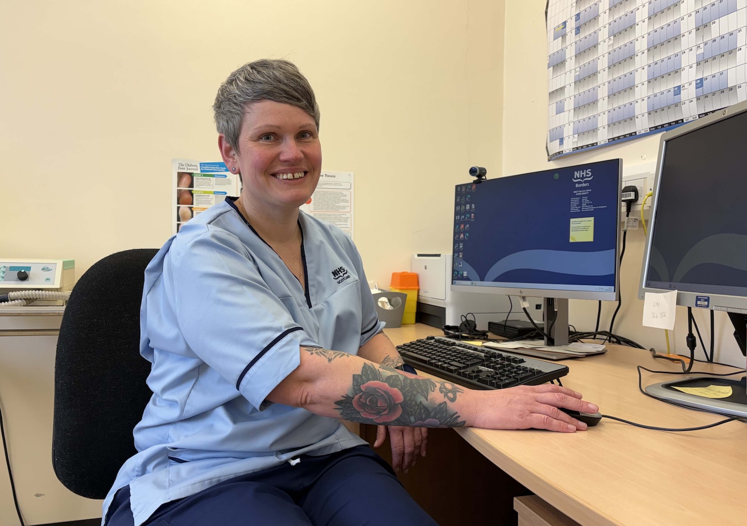 Photograph of Gemma Smail sitting at her work desk
