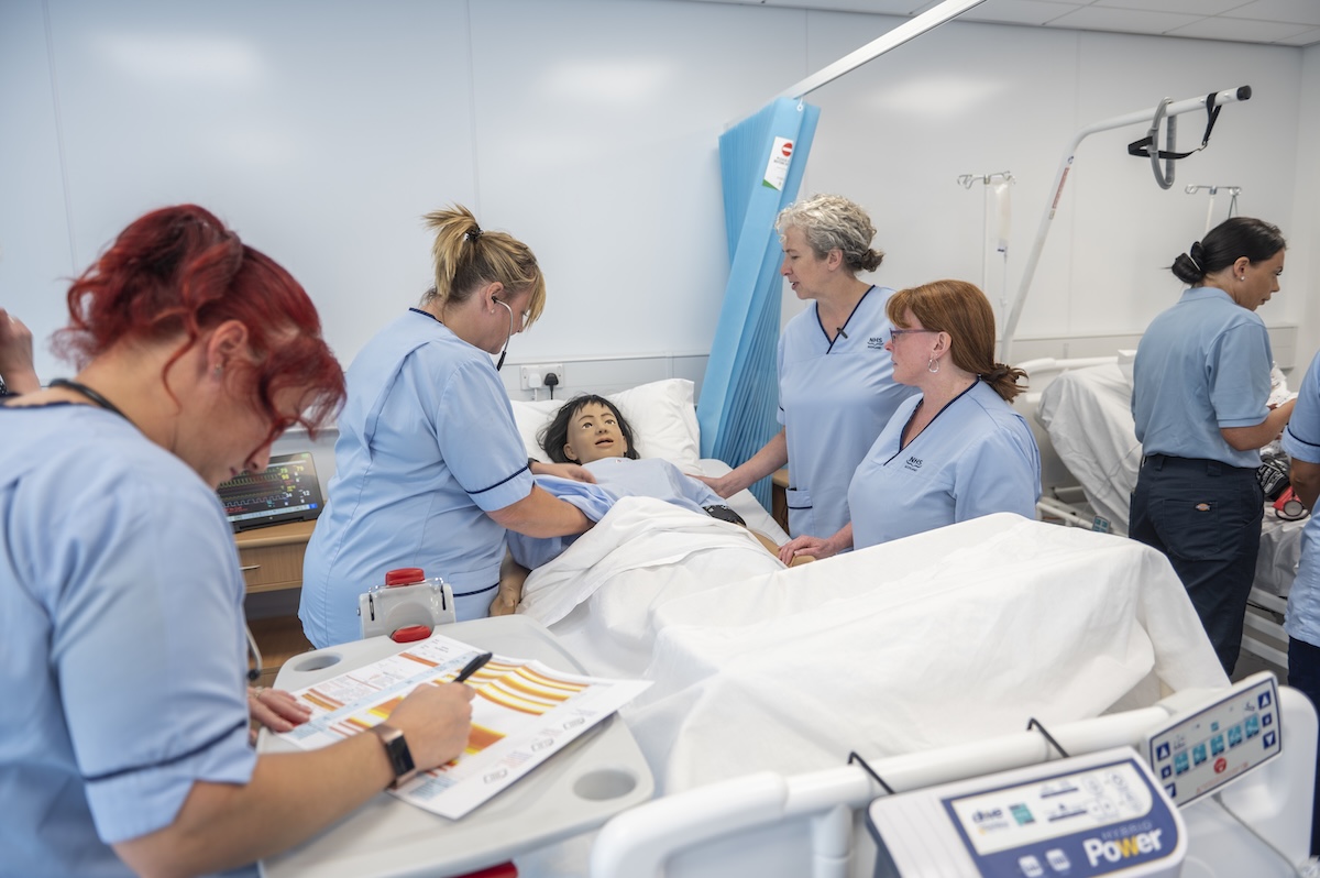 Photo showing a group of student nurses studying in a simulated ward