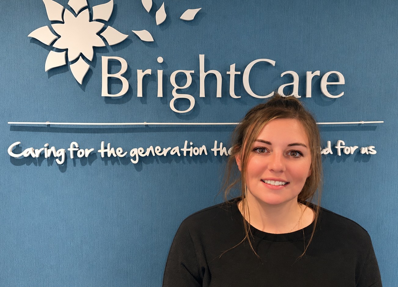 Photo of Dani Marr standing in front of the Bright Care signage