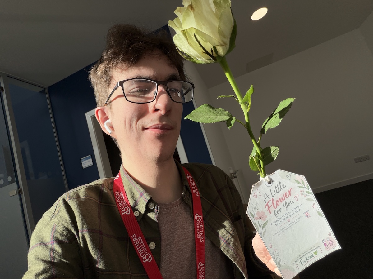 Photo of Borders College staff member Ryan Murdie holding a flower